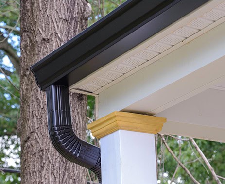 Durable black gutter system installed on residential roof for effective water drainage.