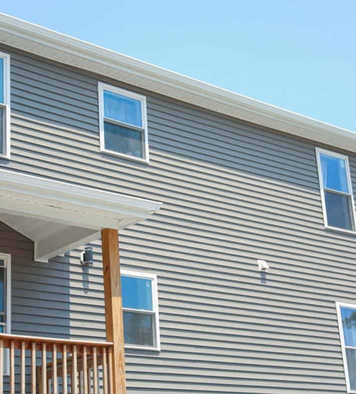 Modern house with new gray vinyl siding installed by BlueSky Roofing & Siding.