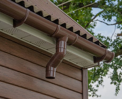 Durable brown gutter system installed on house exterior.