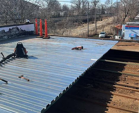 Corrugated metal roof panels being installed on a residential roof; roof replacement in NJ