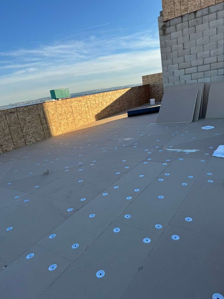 Flat roof replacement prep with numerous blue fastener disks on gray decking in Clifton NJ
