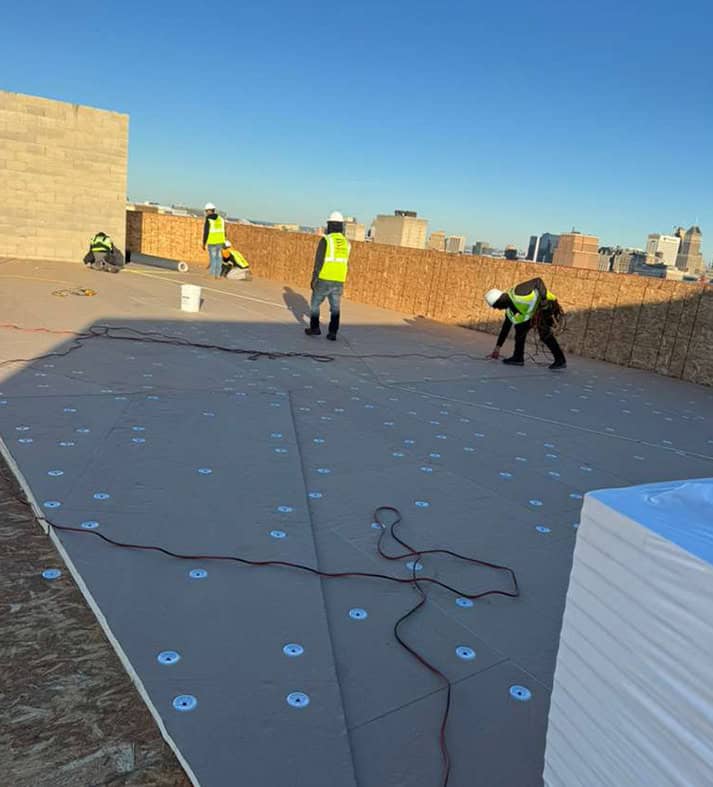 BlueSky roofing crew performing roof replacement on a flat rooftop in New Jersey