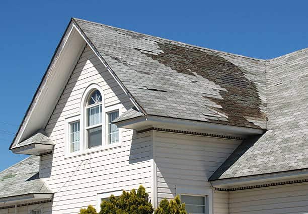 Damaged asphalt roof with missing shingles before roof replacement in Clifton NJ