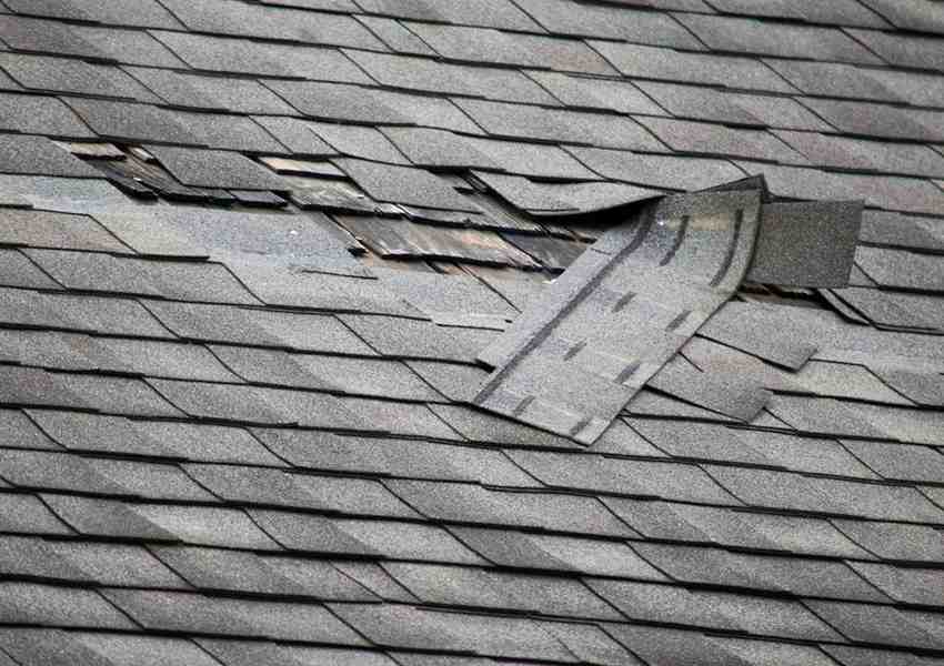 Damaged asphalt roof with missing shingles before roof replacement in Clifton NJ