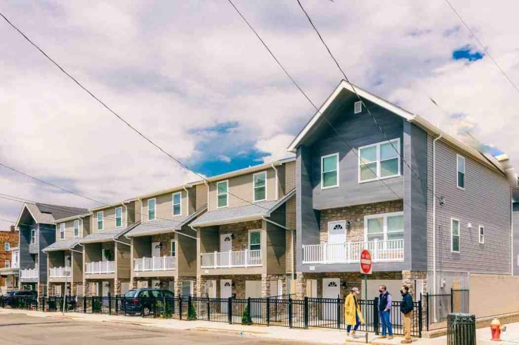 Blue-gray siding installation on a row of townhomes with stone veneer in New Jersey.