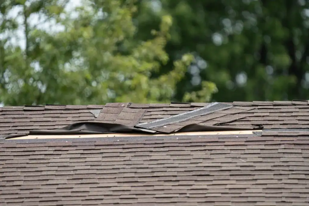 Damaged asphalt roof with missing shingles before roof replacement in Clifton NJ
