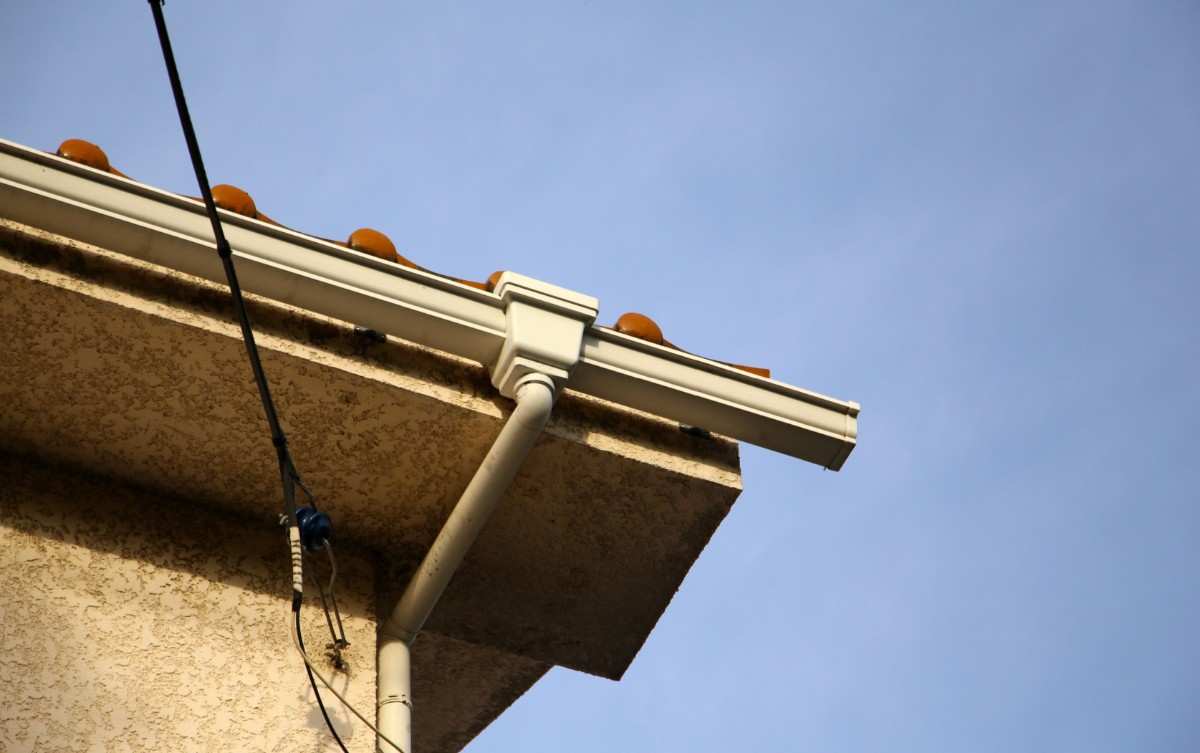White gutter installation along a home roofline in Clifton, NJ for gutter repair and replacement services