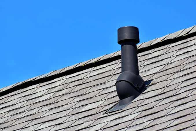 Black roof vent pipe with curved elbow installed on a shingle roof in Bloomfield, NJ.