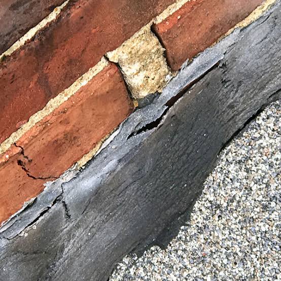Roof leak repair: cracked underlayment along brick masonry edge.