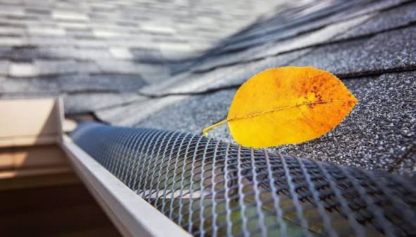 Yellow leaf resting on a metal gutter guard installed along the roof edge of a Princeton, NJ home.
