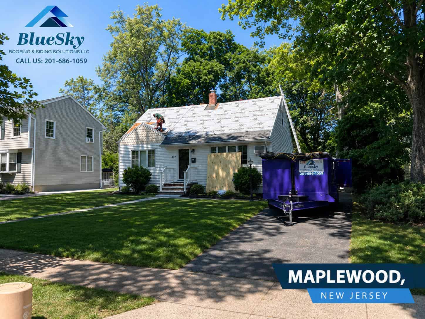 Roof replacement in Maplewood, New Jersey: worker on roof installing underlayment beside a purple trailer at a home.