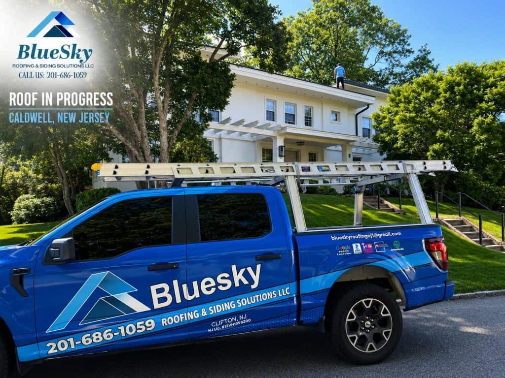 Roof replacement underway as BlueSky truck with ladder rack sits beside a white two-story home in Caldwell.