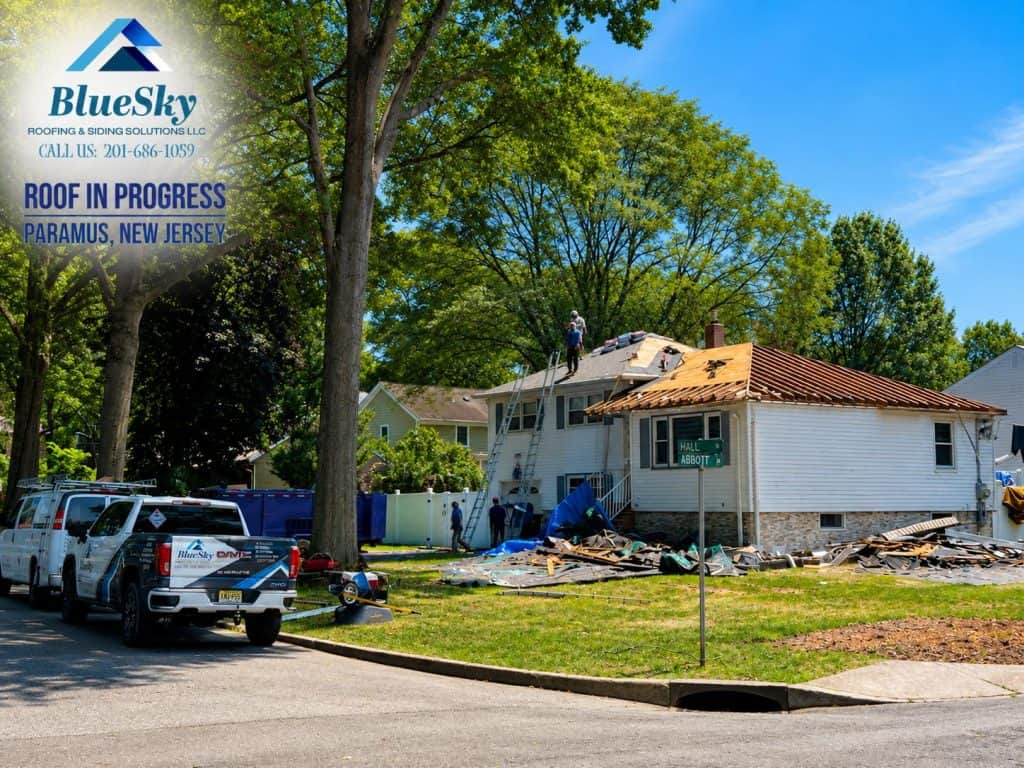 Roof replacement underway on Paramus, New Jersey home with workers on the roof.