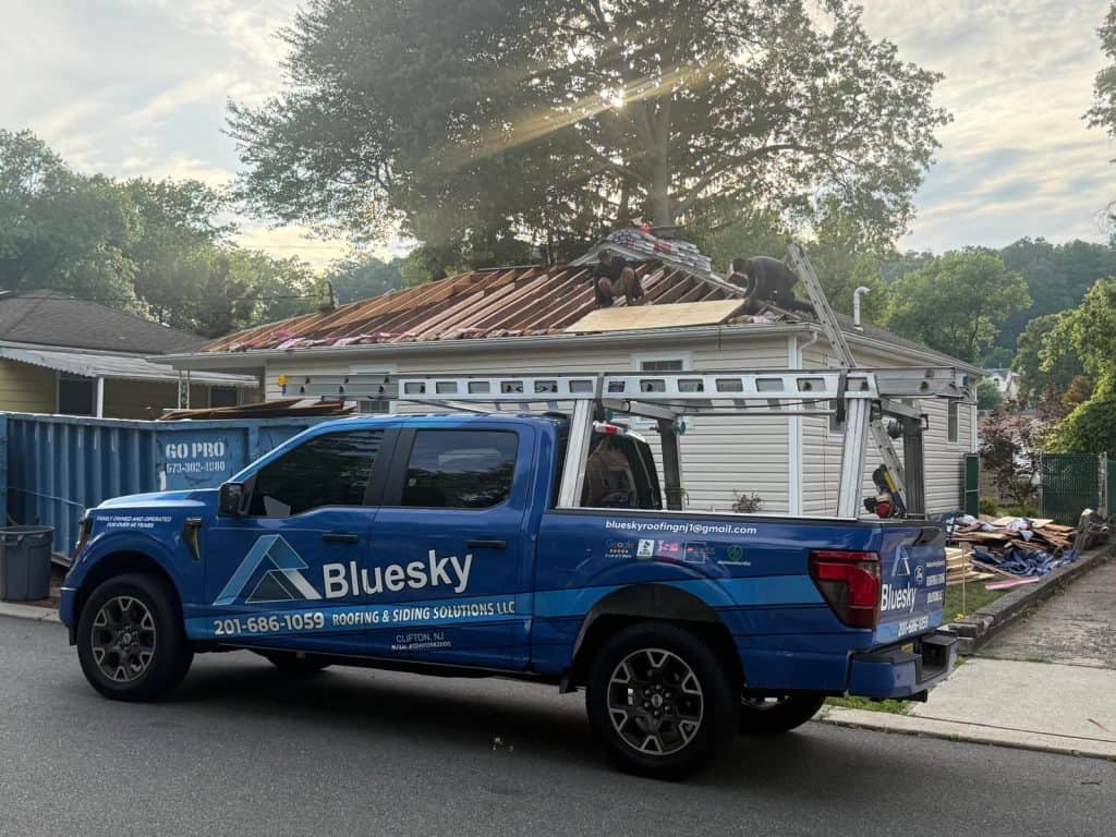BlueSky roofing crew on a residential roof with exposed plywood during roof replacement in NJ