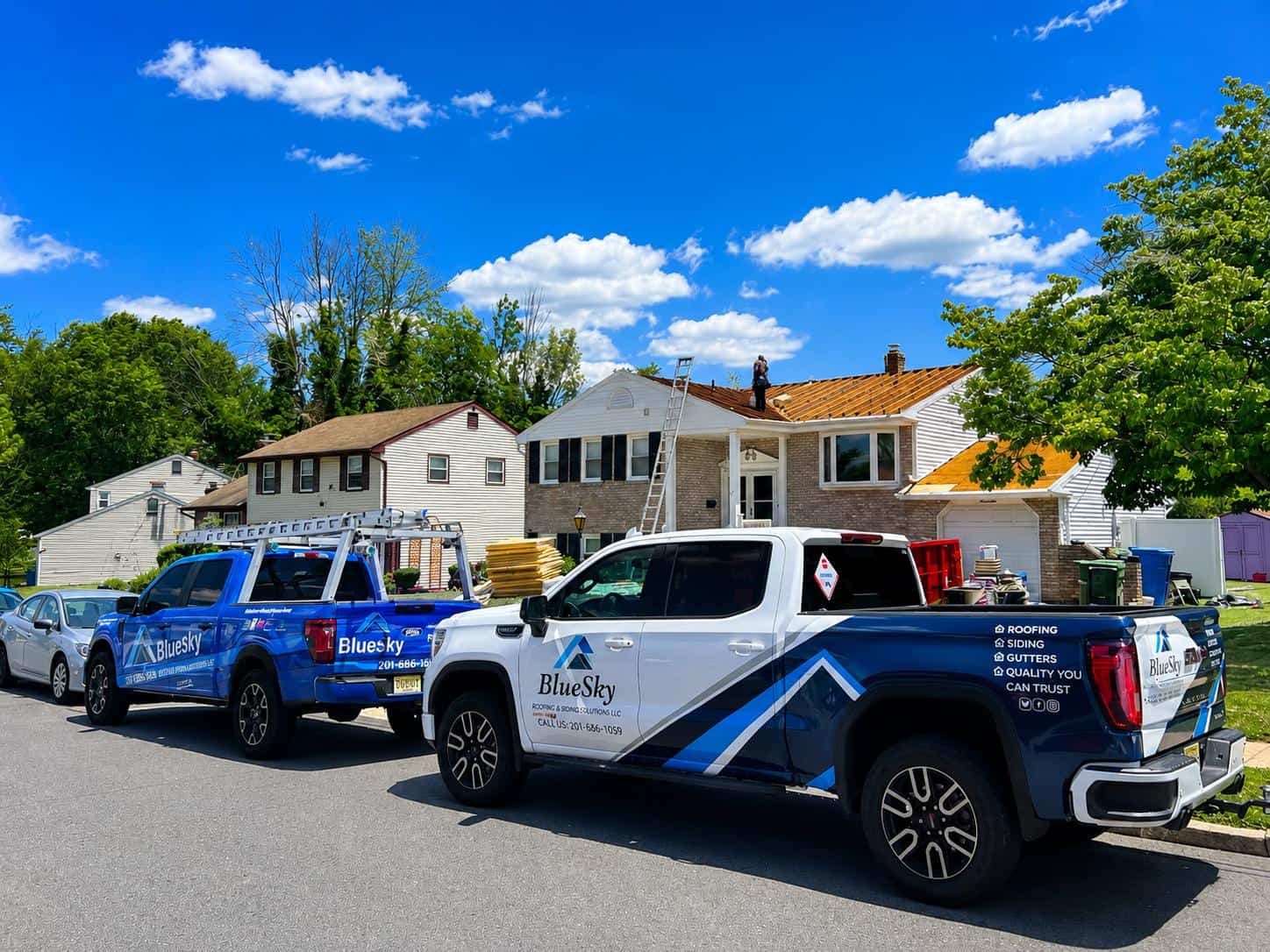 BlueSky roofing crew performing roof replacement on a two-story home in Clifton, NJ