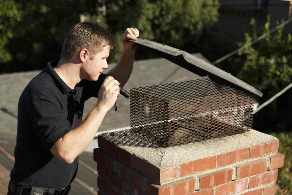 Roofer performing chimney repair on brick chimney on a roof in New Jersey