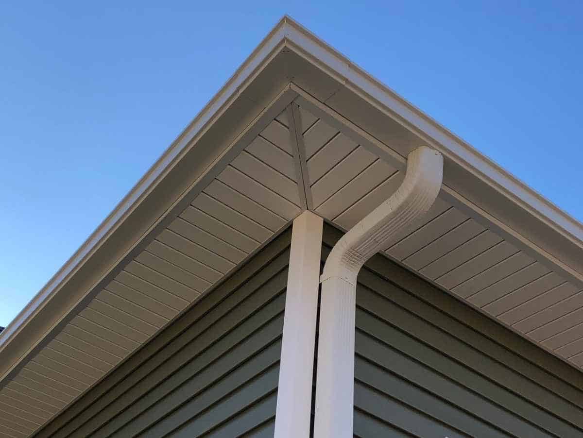 White seamless gutter and downspout installed on a residential home