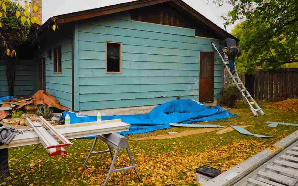 Storm-damaged teal siding on a home in Livingston, NJ requiring professional siding repair and replacement.